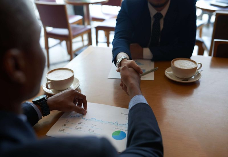 Business partners shaking hands before discussing project