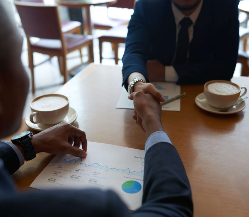 Business partners shaking hands before discussing project