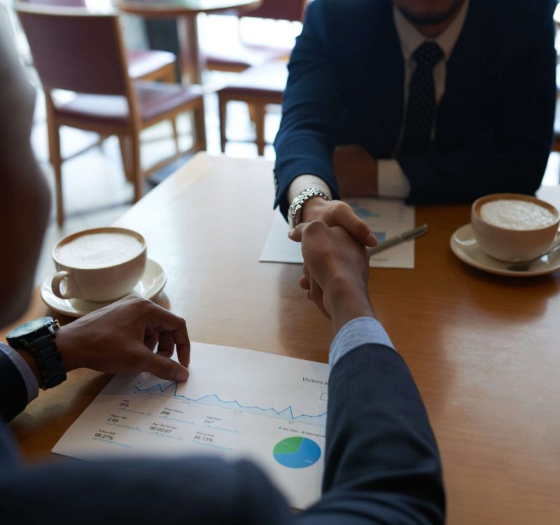 Business partners shaking hands before discussing project