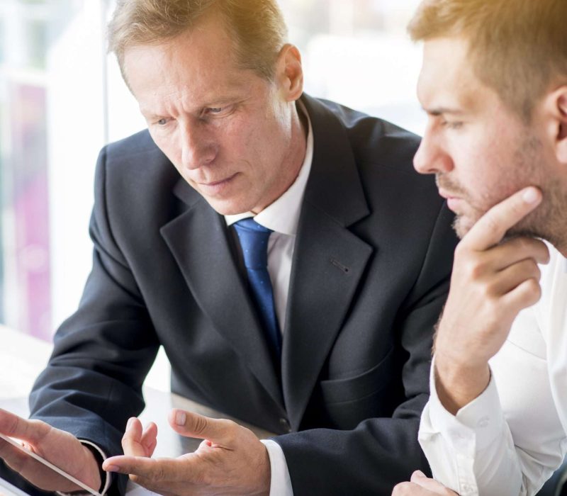 two-businessman-discussing-business-plan-digital-tablet