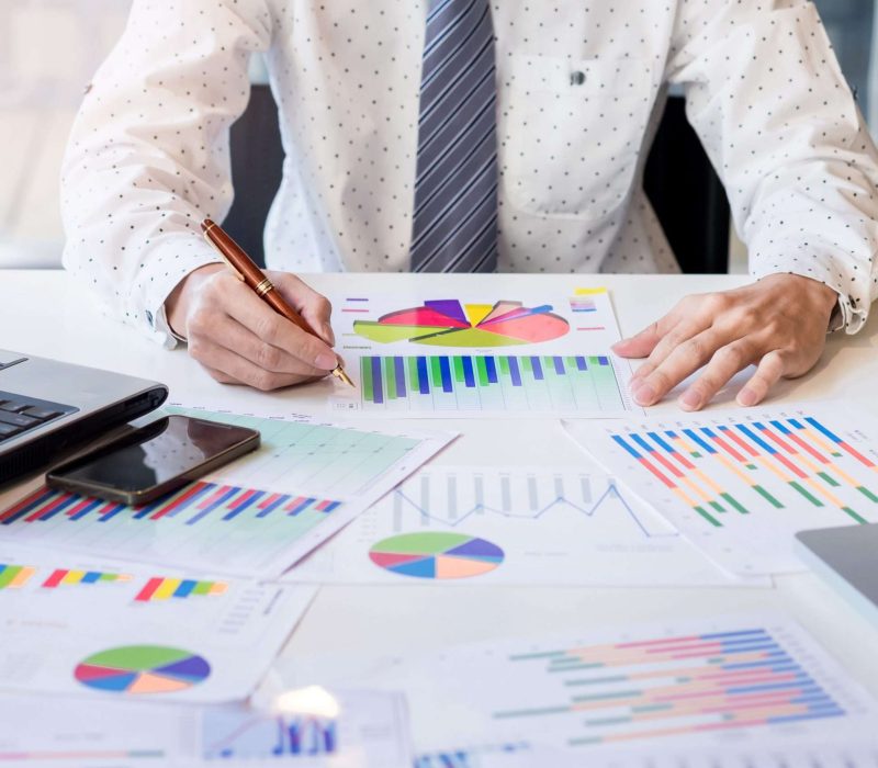 Working process startup. Businessman working at the wood table with new finance project. Modern notebook on table. Pen holding hand