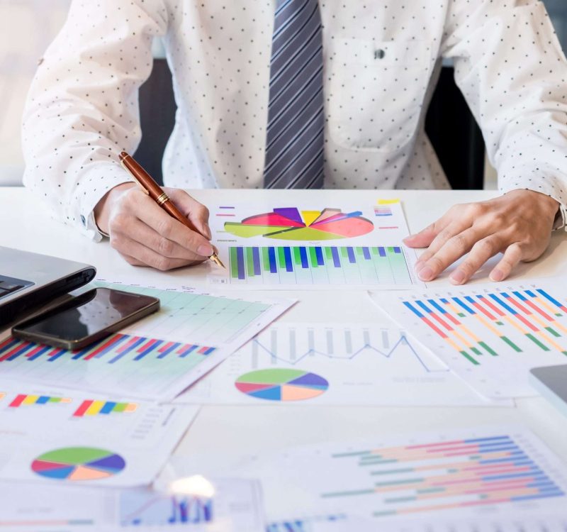 Working process startup. Businessman working at the wood table with new finance project. Modern notebook on table. Pen holding hand